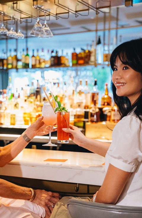 two women cheering with cocktails